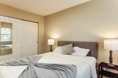 a bedroom with a large white bed with two lamps at 6 Mi to Downtown Cincy Group-Friendly Townhome! in Cincinnati