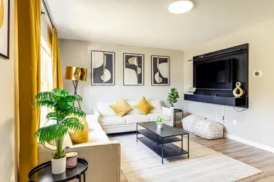 a living room with a white couch and a tv at 6 Mi to Downtown Cincy Group-Friendly Townhome! in Cincinnati