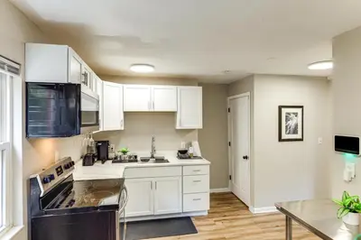 a kitchen with white cabinets and a black appliances at 6 Mi to Downtown Cincy Group-Friendly Townhome! in Cincinnati