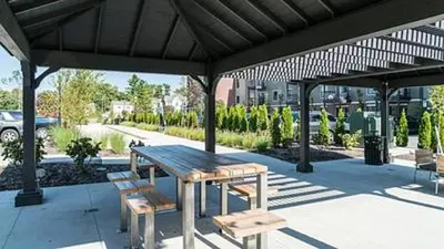 a wooden picnic table and benches under a pavilion at Landing Stylish 1BD Yoga Studio Gym in Grove City