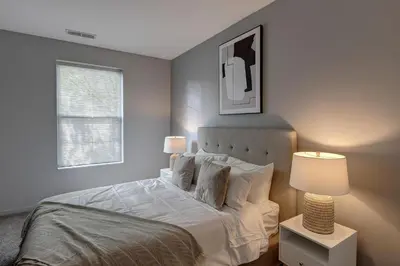 a bedroom with a bed with white sheets and pillows at Landing Stylish 1BD Yoga Studio Gym in Grove City