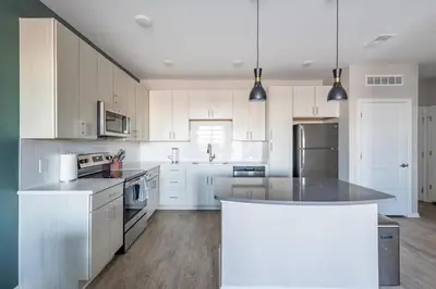 a kitchen with white cabinets and a large island at Landing Chic 1BD Yoga Studio Gym in Florence