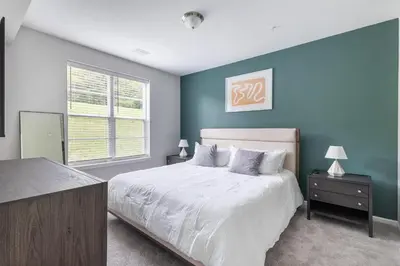 a bedroom with a large bed with blue walls at Landing Apartment - Tapestry Ridge in Fort Wright