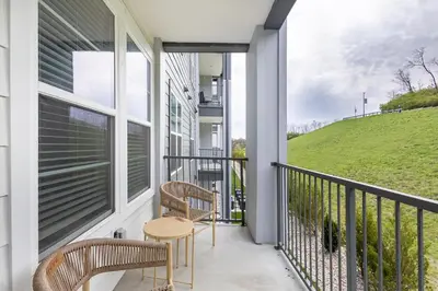 a balcony with two chairs and a table at Landing Apartment - Tapestry Ridge in Fort Wright