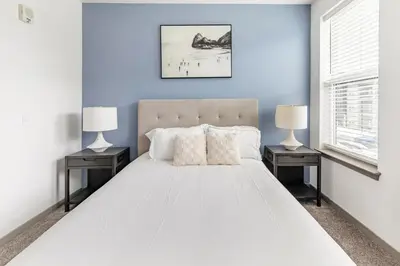 a bedroom with a large white bed with two night stands at Landing Incredible 1BD Courtyard Gym