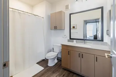 a bathroom with a toilet and a sink and a mirror at Landing Incredible 1BD Courtyard Gym
