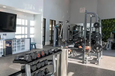 a room with a gym with a man laying on a bench at Landing Stunning 2BD in Manhattan Harbour in Cincinnati