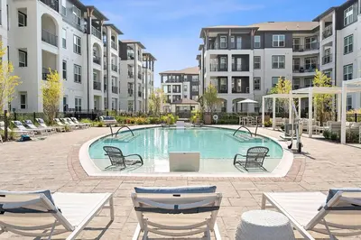 a swimming pool in a courtyard with chairs and buildings at Landing Stunning 2BD in Manhattan Harbour in Cincinnati