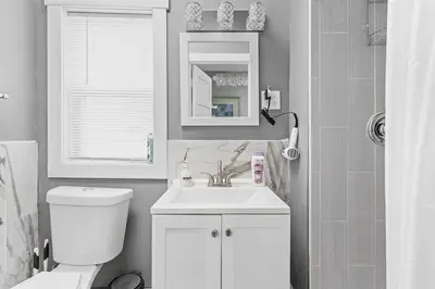a bathroom with a toilet and a sink and a mirror at Elegant 1BR Workspace Near Parks and Summit Lake in New Castle