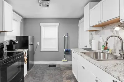 a kitchen with a sink and a refrigerator at Elegant 1BR Workspace Near Parks and Summit Lake in New Castle