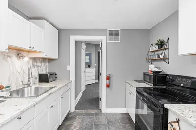 a kitchen with white cabinets and a sink at Elegant 1BR Workspace Near Parks and Summit Lake in New Castle