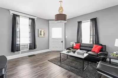 a living room with a black couch and red pillows at Stylish New Castle Escape with Garage and by Parks-Family Friendly in New Castle