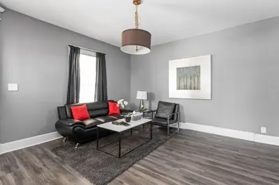 a living room with a black leather couch and a table at Stylish New Castle Escape with Garage and by Parks-Family Friendly in New Castle
