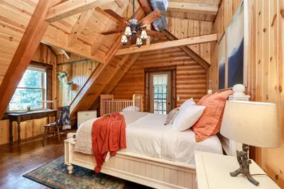 a bedroom with a bed in a log cabin at Family-Favorite Cabin with Private Seasonal Pool and Movie Theater in Celina
