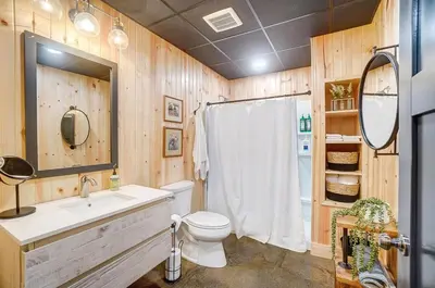 a bathroom with a toilet and a sink and a mirror at Family-Favorite Cabin with Private Seasonal Pool and Movie Theater in Celina