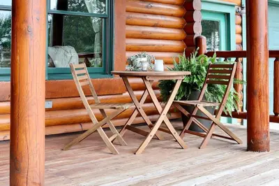 two chairs and a table on the porch of a cabin at Family-Favorite Cabin with Private Seasonal Pool and Movie Theater in Celina