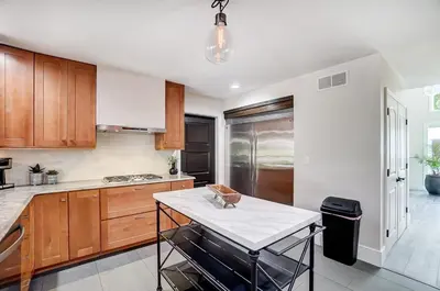 a kitchen with wooden cabinets and a white counter top at Spacious Family Gem Near Lake & State Park with Pool and Hot Tub in Celina