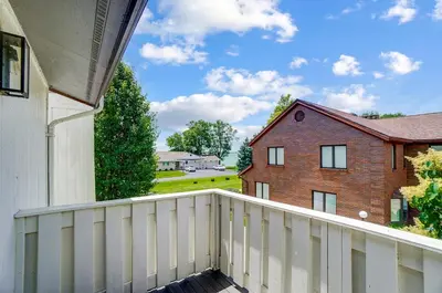 a balcony with a white fence and a brick house at Spacious Family Gem Near Lake & State Park with Pool and Hot Tub in Celina