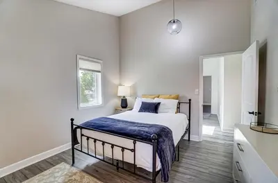 a bedroom with a bed with a blue blanket on it at Spacious Family Gem Near Lake & State Park with Pool and Hot Tub in Celina