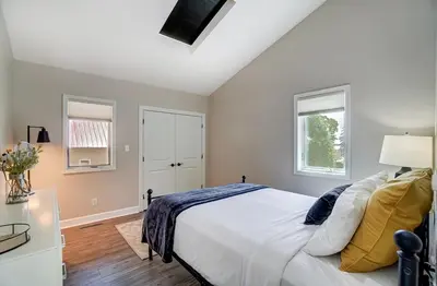 a bedroom with a white bed and two windows at Spacious Family Gem Near Lake & State Park with Pool and Hot Tub in Celina