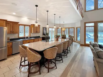 a kitchen with a large island with bar chairs at Grand Lake Getaway with Pool, Boat Dock - Sleeps 22 in Celina