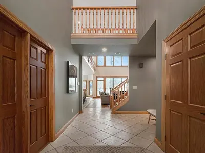 a hallway with a wooden door and a staircase at Grand Lake Getaway with Pool, Boat Dock - Sleeps 22 in Celina