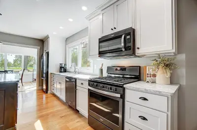 a kitchen with white cabinets and a stove top oven at Golf Course Home with Pool and Hot Tub Near Lake and State Park in Celina