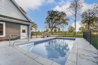 a swimming pool in the backyard of a house at Golf Course Home with Pool and Hot Tub Near Lake and State Park in Celina