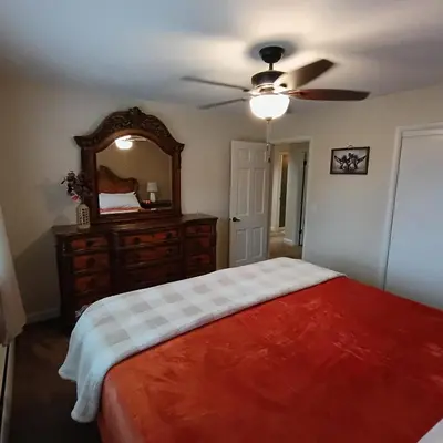 a bedroom with a bed with a dresser and a mirror at Cliffside Cottage in Mansfield