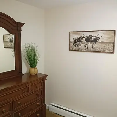 a room with a dresser and a picture of cows on the wall at Cliffside Cottage in Mansfield