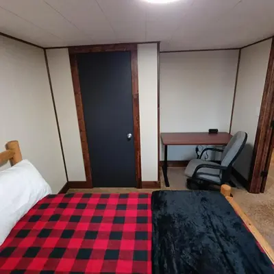 a room with a bed and a desk and a door at Cliffside Cottage in Mansfield