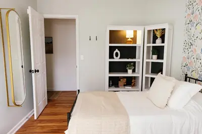 a bedroom with a white bed and white shelves at 