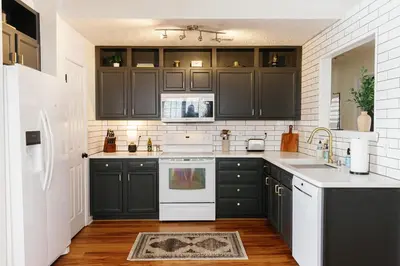a kitchen with black cabinets and white appliances at 