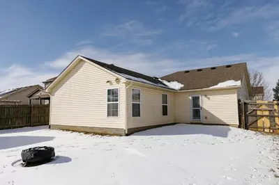 a white house with a snow covered yard at 