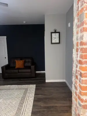 a living room with a couch and a clock on a wall at Brand new listing Aimi Luxury Retreat in Dayton