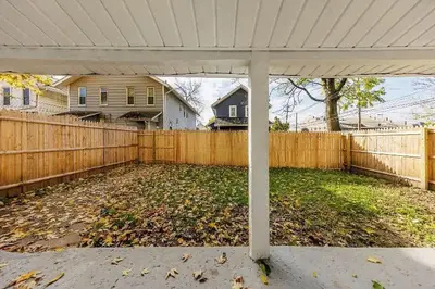 a backyard with a fence and a white pergola at The Beautiful Jenkins Getaway in Columbus