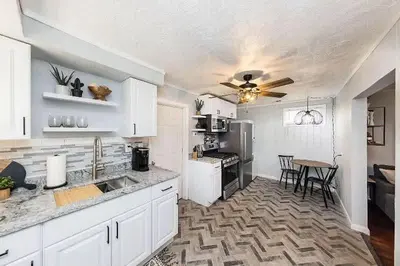 a kitchen with white cabinets and a table in it at The Beautiful Jenkins Getaway in Columbus