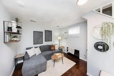 a living room with a gray couch and a table at The Beautiful Jenkins Getaway in Columbus