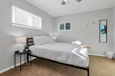 a white bedroom with a bed and a lamp at The Columbus Prime - 5 Bedroom 2 Bath- Parking in Columbus