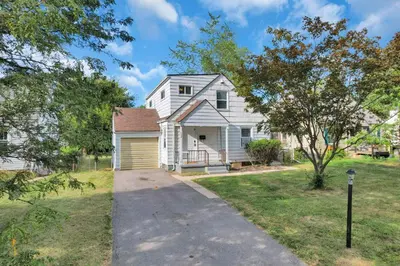 a white house with a garage and a driveway at The Columbus Prime - 5 Bedroom 2 Bath- Parking in Columbus