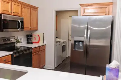 a kitchen with a stainless steel refrigerator and wooden cabinets at Modern Retreat Near DAY Airport & Metropark in Vandalia