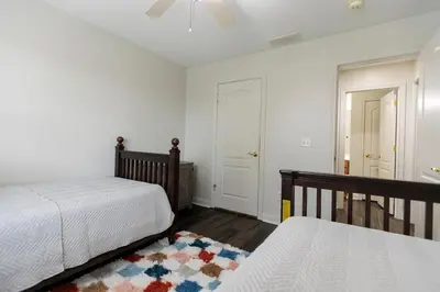 a bedroom with two beds and a rug at Modern Retreat Near DAY Airport & Metropark in Vandalia