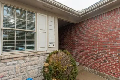 a house with a brick wall and a window at Modern Retreat Near DAY Airport & Metropark in Vandalia