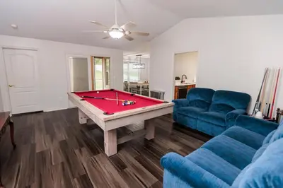 a living room with a pool table and a blue couch at Modern Retreat Near DAY Airport & Metropark in Vandalia