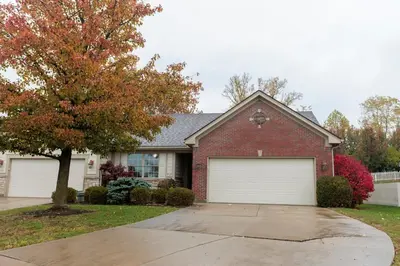 a red brick house with a white garage at Modern Retreat Near DAY Airport & Metropark in Vandalia