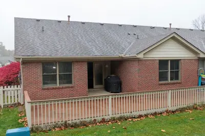 a red brick house with a white fence at Modern Retreat Near DAY Airport & Metropark in Vandalia