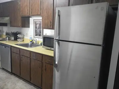 a white refrigerator in a kitchen with wooden cabinets at Lakewood Apartment No 9 in Lakewood