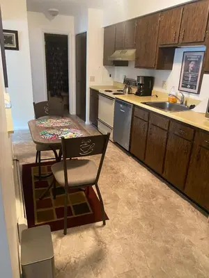 a kitchen with a table and a kitchen with wooden cabinets at Lakewood Apartment No 9 in Lakewood