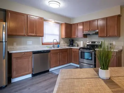 a kitchen with wooden cabinets and stainless steel appliances at Lovely West Akron home with attached private garage in Akron