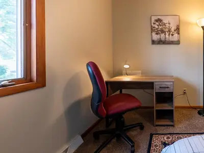 a room with a desk with a red chair and a window at Lovely West Akron home with attached private garage in Akron